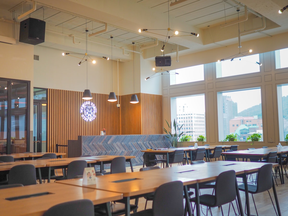 Belebte Mensa-Cafeteria mit Studierenden als Symbol für Gästeschwankungen und Bedarfsplanung in Großküchen